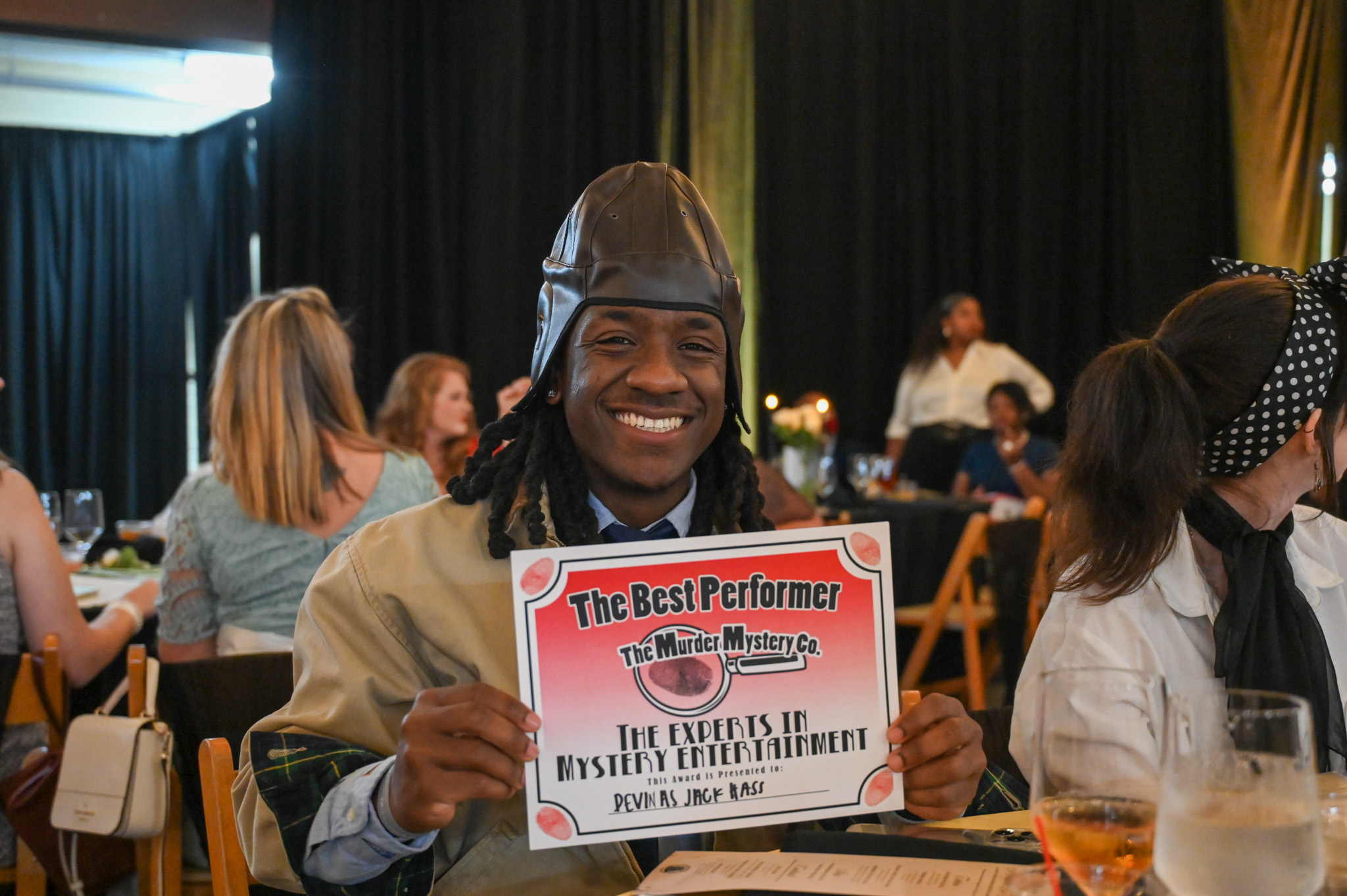 An actor for the Murder Mystery Dinner holding a certificate that states