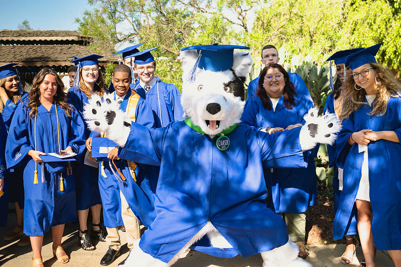 Graduates celebrate with mascot Chaser