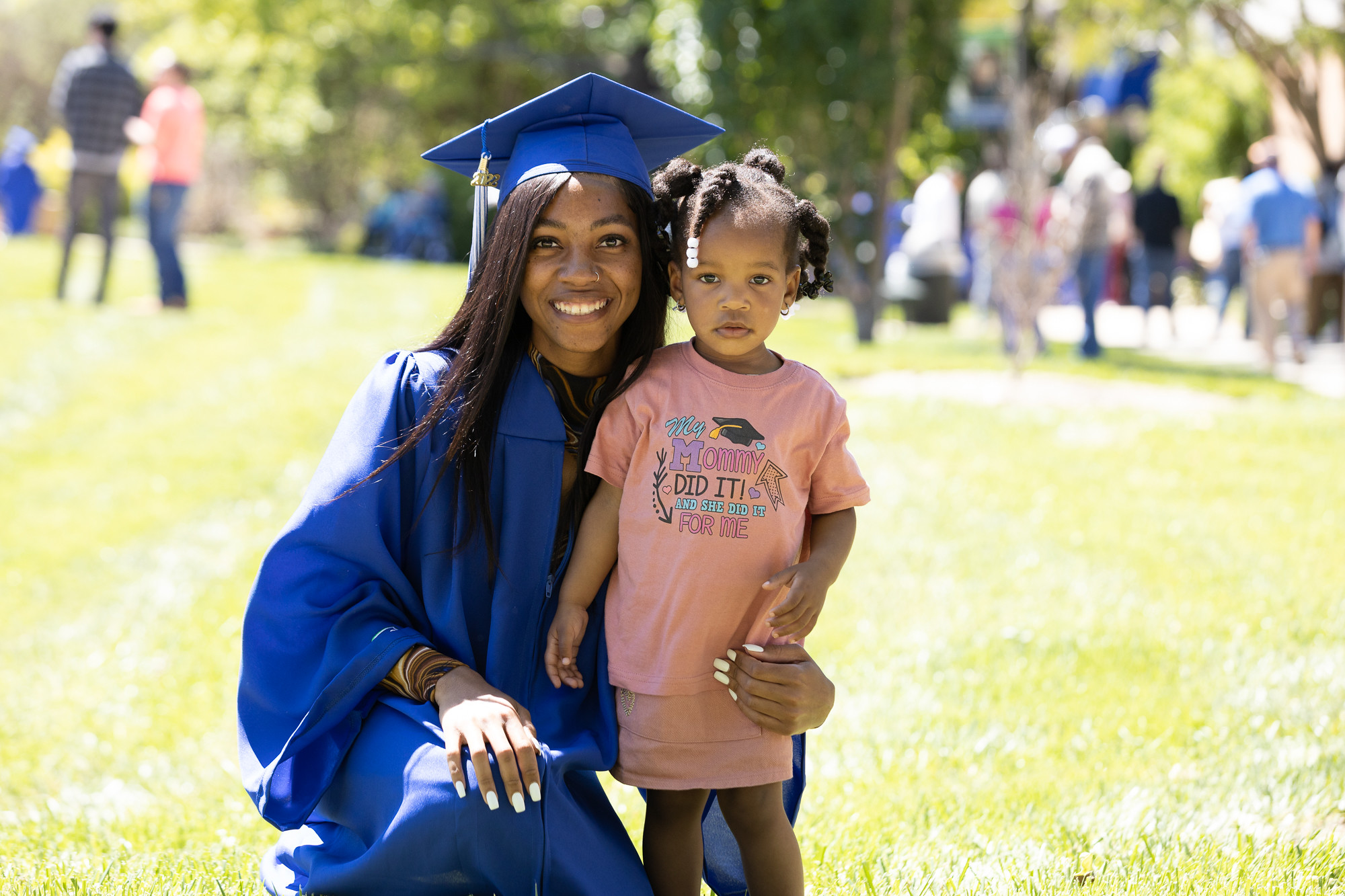 An SCC graduate stands with her young daughter.