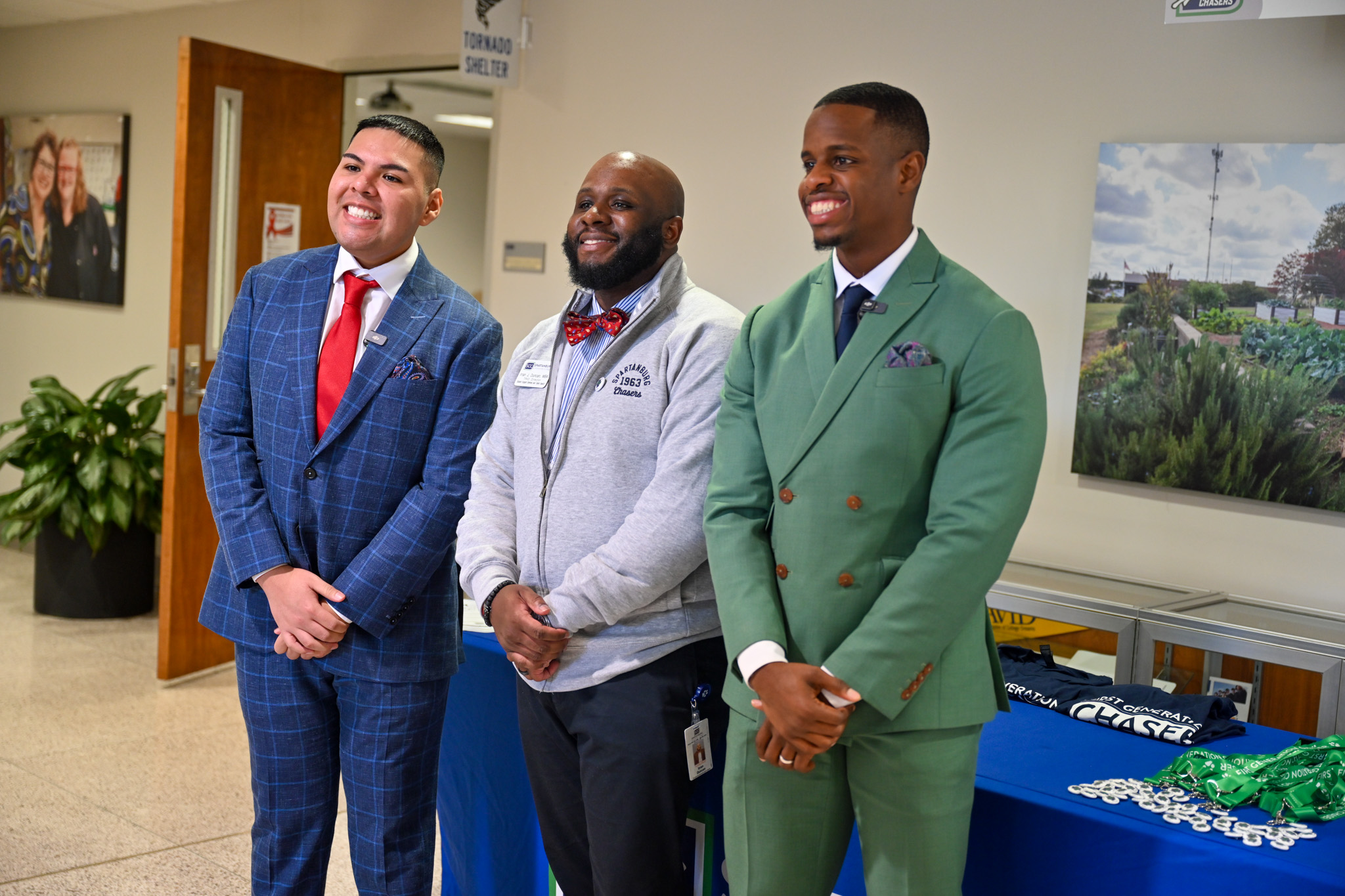Three men in suits smile while they pose for a picture